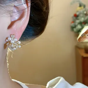 Detailed macro view of an elegant gold plated pearl and zircon firework stud earring