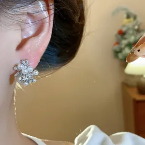 Detailed view of elegant firework pearl stud earrings with sparkling zircons worn on ear