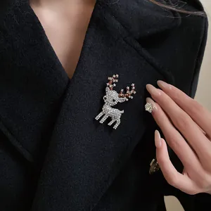 Close-up of elegant rhinestone reindeer brooch pinned on a stylish black wool coat.