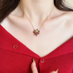 Detailed view of 18k gold plated zircon firework pendant necklace on model's neck.