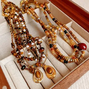Vue détaillée d'élégants colliers en perles d'œil de tigre vintage dans une boîte à bijoux