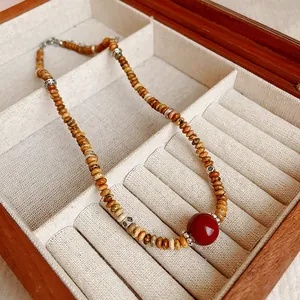 Vue rapprochée d'un collier en œil de tigre vintage avec une pierre rouge centrale éclatante