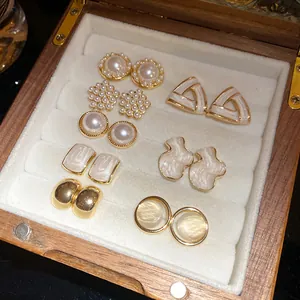 Elegant 16-piece gold and pearl earring set displayed inside a premium wooden jewelry box