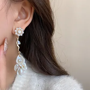 Detailed view of elegant floral tassel earrings featuring pearls and sparkling zircons