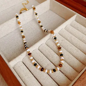 Gros plan d'un collier de perles en pierre d'œil de tigre de style Maillard rétro