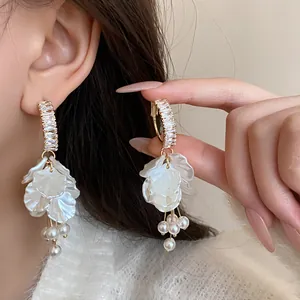 Detailed macro view of elegant silver needle zircon and pearl flower tassel earrings