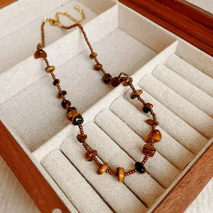 Vue détaillée des perles en pierre d'œil de tigre et de l'esthétique rétro du bijou