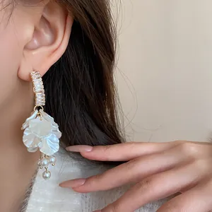 Close-up showing the elegant floral tassel earring featuring zircons and pearl accents