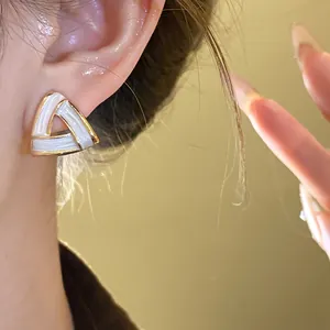 Geometric triangle stud earring with gold-tone edges and white enamel detail