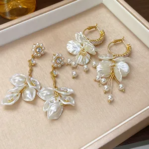 Detailed view of elegant gold-tone earrings with pearl petals and zircon flower accents
