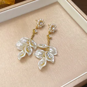 Macro view of elegant pearl flower dangle earrings with sparkling zircon accents on tray