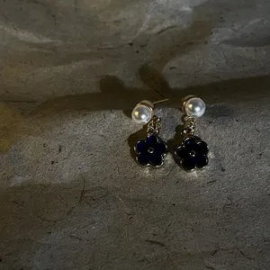 Dettaglio orecchini a perno stile rétro francese con fiori in smalto blu scuro