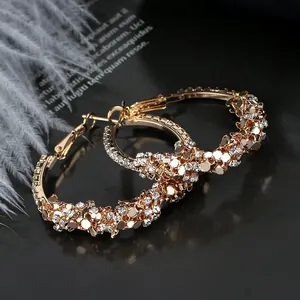 Detailed view of gold hoop earrings featuring sparkling rhinestones and golden sequins