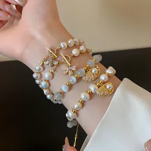 Close-up of vintage gold-plated bracelets with pearls, cat's eye stones, and bee charms