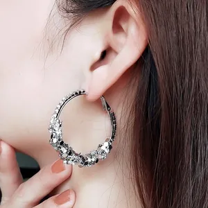 Close-up of oversized silver hoop earrings with sparkling sequins and rhinestones