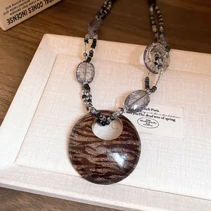 Vista dettagliata di una collana bohémien in resina con un ciondolo a ciambella leopardato