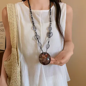 Collana bohémien in resina con ciondolo leopardato indossata da una modella