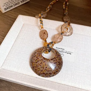 Primo piano di collana bohémien in resina con ciondolo leopardato e perline