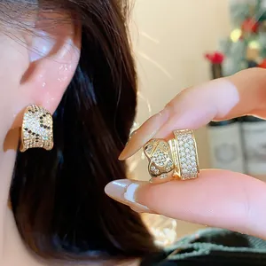Close-up of 18k gold-plated square hoop earrings with pave zircon detailing