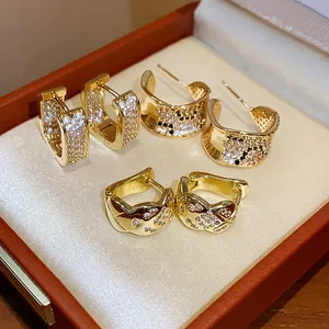Close-up of three different gold plated earring designs featuring cubic zirconia