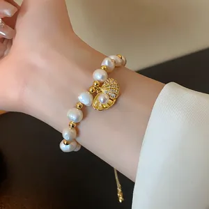 Detail of a vintage pearl bracelet with a zircon-studded seashell charm