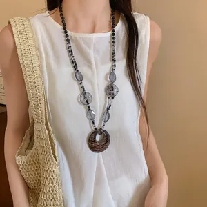 Collana boho con pendente in resina leopardata indossata per un look retrò ed elegante.
