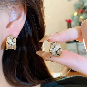 Close-up of 18k gold plated square earrings with black and white pavé zircons