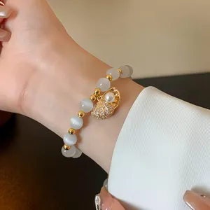 Elegant gold plated cat eye bead bracelet featuring a pearl shell charm in close-up