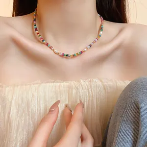 Gros plan d'un collier de perles colorées avec perles baroques sur un cou.