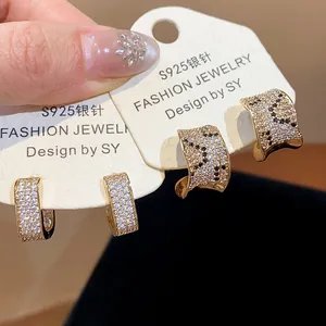Close-up detail of 18k gold-plated zircon ear hoops featuring S925 silver needles