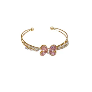 Luxury gold open cuff bracelet featuring a pink zircon butterfly and pearl accents
