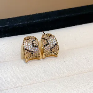 Detailed view of 18k gold plated earrings featuring a sparkling leopard zircon pattern inlay