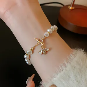 Detailed view of elegant white pearl bracelet featuring a sparkling crystal bee charm