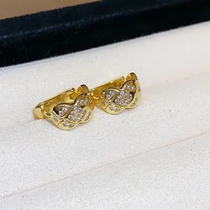 Detail showing 18k gold plated earrings with quilted pattern and zircon stones