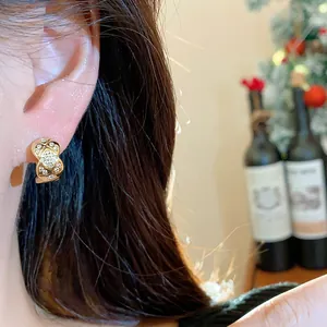 Close-up of 18k gold plated quilted earrings with zircon on Asian model's ear