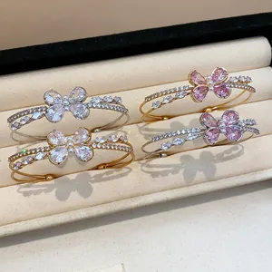 Detail view of four butterfly open bangles with sparkling zircons in a jewelry box