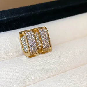 Close-up of 18k gold plated square earrings encrusted with sparkling zirconia stones