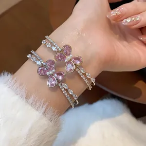 Detailed view of elegant pink zircon butterfly double-layered open bangles on wrist