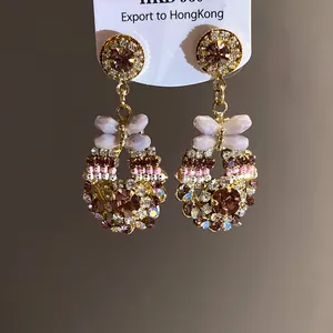 Detailaufnahme von Vintage-Ohrhängern mit funkelnden Kristallen und Glasperlen