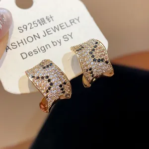 Macro view of gold plated square earrings featuring leopard pattern zirconia stones