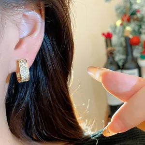 Detailed view of luxury 18k gold plated square hoop earring with CZ pavé on ear