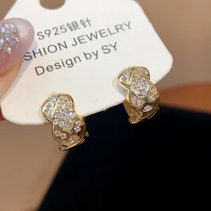 Macro detail showing 18k gold plated hoop earrings with zircon pavé quilted pattern