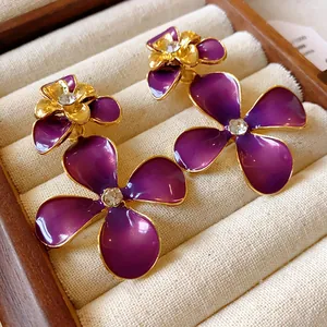 Detailed view of elegant purple enamel floral earrings with gold trim and crystals