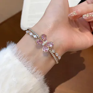Close-up of elegant double-layered open bangle featuring a pink zircon butterfly