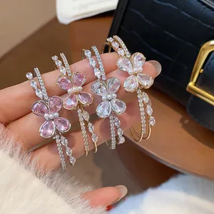 Close-up of sparkling CZ butterfly double-layer bangles in pink and clear crystal