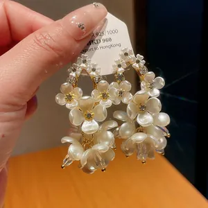 Detailed view of elegant shell flower earrings with shimmering zirconia accents.