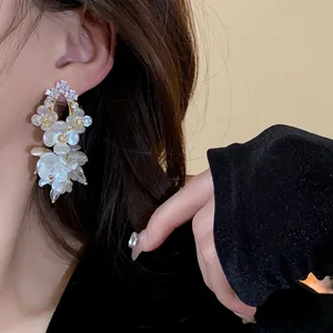 Elegant shell flower earrings with crystals, close-up of delicate French vintage design.