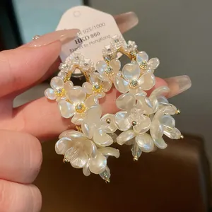 Macro view of vintage white shell flower earrings with shimmering crystal accents