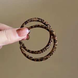 Close-up detail of stylish leopard print leather hoop earrings for a minimalist look