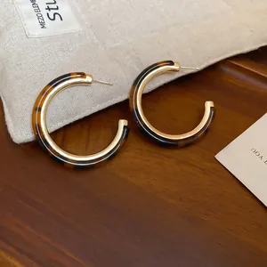 Detailed close-up view of stylish leopard pattern hoop earrings with elegant gold finish